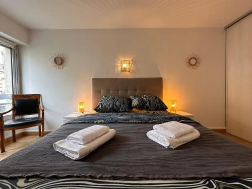 um quarto com uma cama grande com duas almofadas em Cosy apartment at Gates of Paris em Vincennes