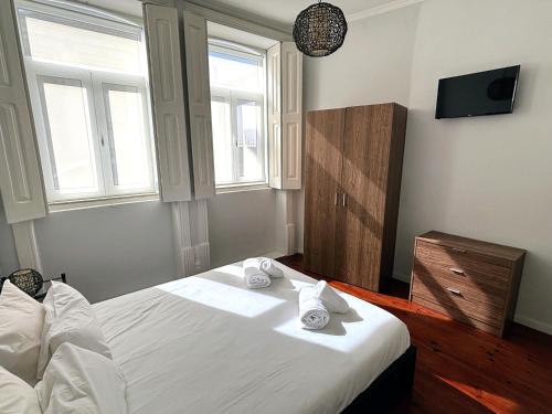 a bedroom with a white bed with towels on it at Covelo Apartment in Porto