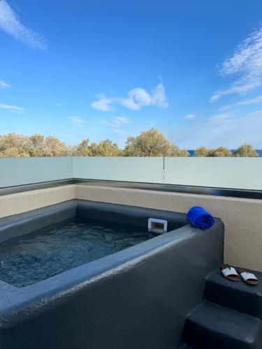 une baignoire jacuzzi avec une serviette bleue dans l'établissement Perissa Bay, à Perissa