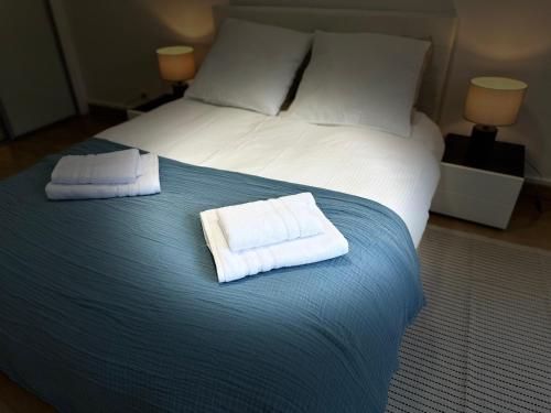 a bed with two towels on top of it at Cosy apartment at Gates of Paris in Vincennes