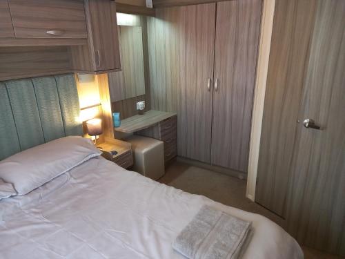 科克茅斯的住宿－Green Dream，卧室配有白色的床和小橱柜。