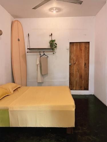 a bedroom with a bed and a surfboard on the wall at Wave Hunters in Arugam Bay