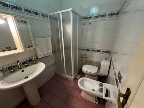 a white bathroom with a sink and a toilet at Terrazza Faraglioni in Acitrezza