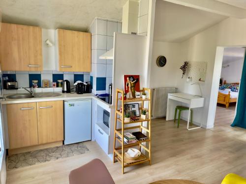 a kitchen with blue and white cabinets and a table at Maison des Chênes 64 - Independant apartment with terrasse in Boucau