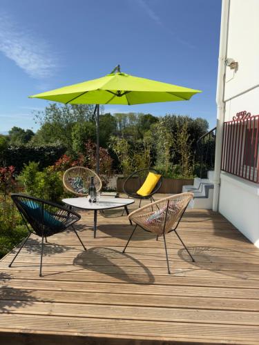 a patio with a table and chairs and an umbrella at Maison des Chênes 64 - Independant apartment with terrasse in Boucau