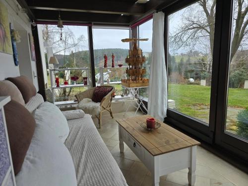 ein Wohnzimmer mit einem Sofa und einem Tisch in der Unterkunft Ferienwohnungen Thomsen Bergdorf Pobershau in Marienberg