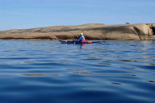 a person in a kayak on a body of water at Kalles, skärgårdsidyll med utsikt över Hamnsundet in Saltvik