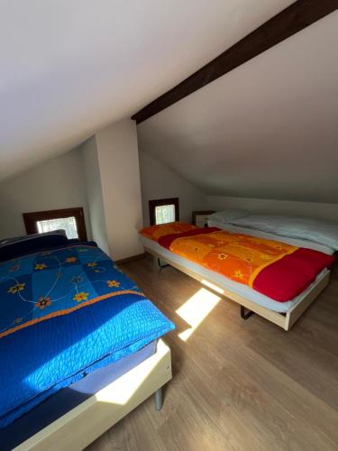 two twin beds in a room with at casa ciliegio in Vogorno