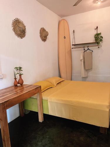 1 dormitorio con cama y tabla de surf en la pared en Wave Hunters, en Arugam Bay