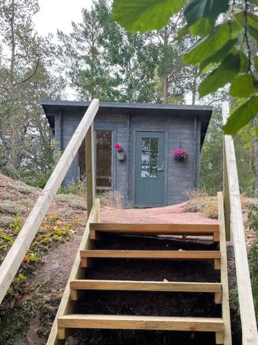 a small house with a staircase leading up to it at Kalles, skärgårdsidyll med utsikt över Hamnsundet in Saltvik