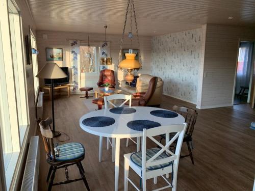 a living room with a white table and chairs at Kalles, skärgårdsidyll med utsikt över Hamnsundet in Saltvik