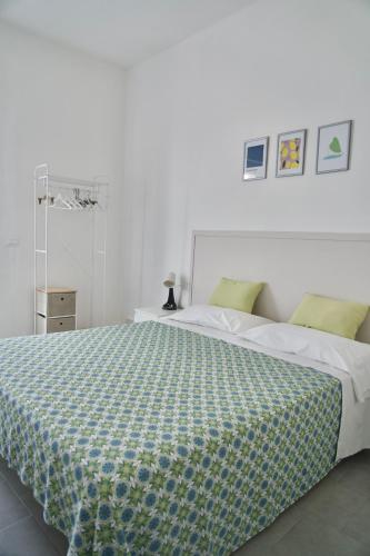 a bedroom with a bed with a green and white comforter at Amoenus Bed & Breakfast in family in Soverato Marina