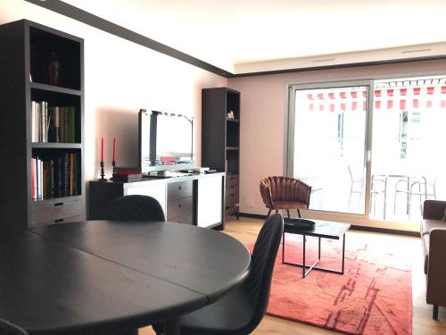 un salon avec une table et des chaises de salle à manger dans l'établissement LE SORNIN - Garage - Clim - Hypercentre - Terrasse, à Vichy