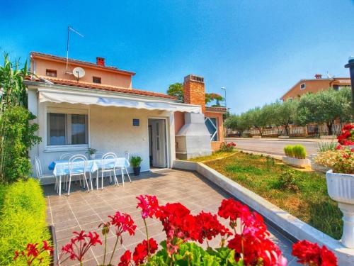 una casa con un patio con flores rojas en Ferienwohnung für 6 Personen ca 75 qm in Fažana, Istrien Istrische Riviera - b54751, en Fažana