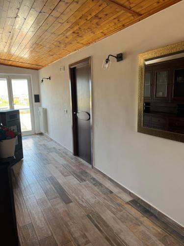 an empty living room with a wooden ceiling at Come a Casa in Paestum