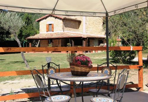 ein Tisch und Stühle mit einem Blumenkorb darauf in der Unterkunft Casale Terre del Farfa in Toffia