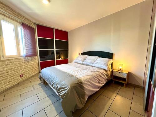 a bedroom with a large bed and a red wall at Appartement ALERIA 2/4 personnes in Aléria