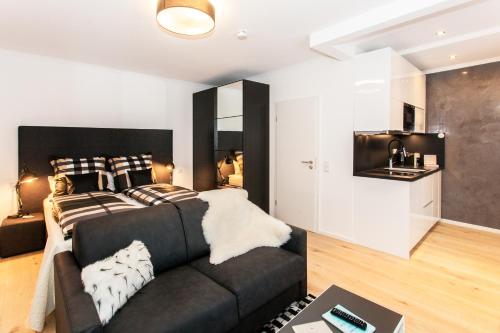 a living room with a couch and a kitchen at Little Oasis Near Frankfurt in Neulsenburg