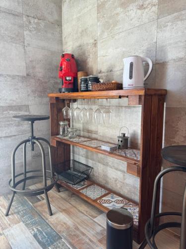 a shelf with some glasses and two stools at Come a Casa in Paestum