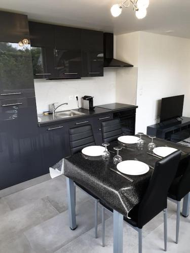 - une cuisine avec une table, des chaises et un évier dans l'établissement Logement Proche Disneyland et Paris, à Pomponne