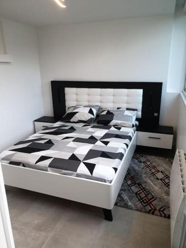 - un lit avec une couette en noir et blanc dans une chambre dans l'établissement Logement Proche Disneyland et Paris, à Pomponne