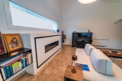 uma sala de estar com um sofá branco e um piano em Ferienhaus mit Privatpool für 4 Personen ca 380 qm in Torretta, Sizilien Nordküste von Sizilien em Torretta