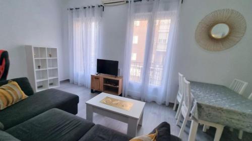 ein Wohnzimmer mit einem Sofa und einem Tisch in der Unterkunft Renovado apartamento en Delicias by beBalmy in Madrid