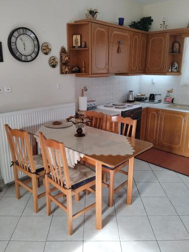 a kitchen with a table and chairs and a clock on the wall at Lina's House Pramanta in Pramanta