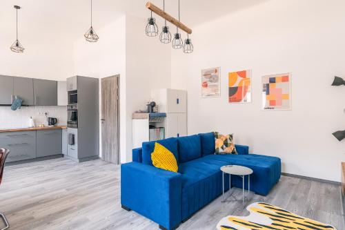 uma sala de estar com um sofá azul e uma cozinha em Heroes' Square Stay em Budapeste