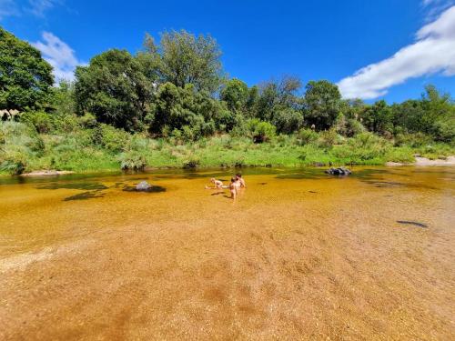 a person standing in the water in a river at Tinkuy in Cosquín