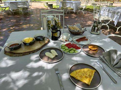 una mesa blanca con platos de comida. en Guest House Rilindja Valbone en Valbonë
