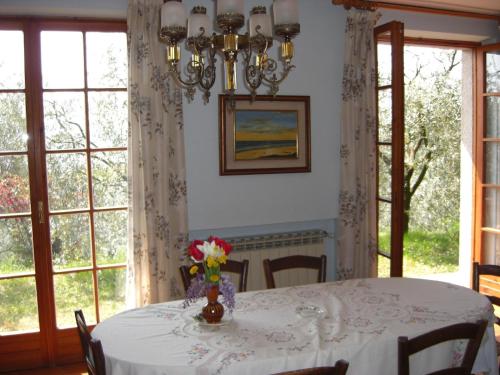 een eetkamer met een tafel met een vaas met bloemen erop bij Ferienwohnung für 4 Personen ca 100 qm in Marciaga, Gardasee Ostufer Gardasee in Marciaga