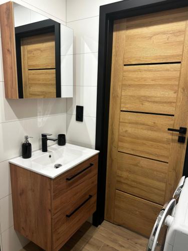 bagno con lavandino e porta in legno di Apartament Helenka a Zabrze