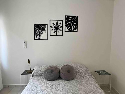 a bedroom with a bed with four pictures on the wall at Complejo Wine Maipu: Piscina, Parrilla, Bicis in Maipú