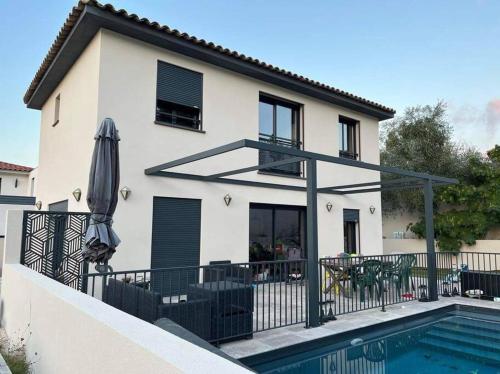 a house with a swimming pool and an umbrella at Villa privée piscine en Provence in Rougiers
