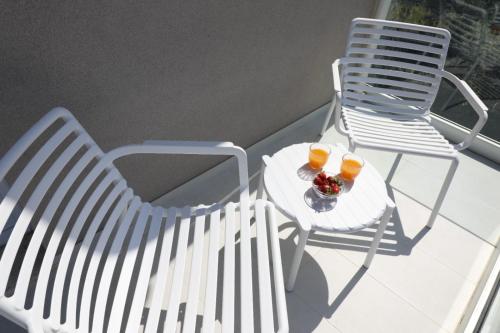 two chairs and two glasses of orange juice on a balcony at Il Narciso Residence in Tropea