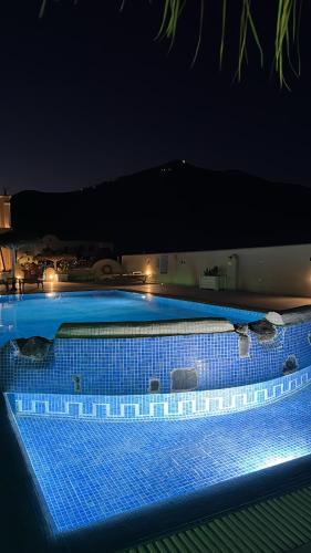 a large swimming pool at night with lights on it at Perissa Bay in Perissa