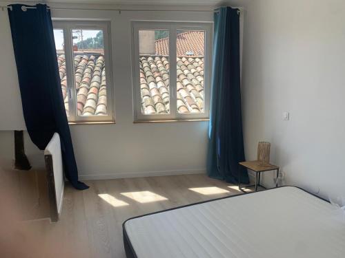 1 dormitorio con 1 cama y 2 ventanas en Le Jalet en Provence - Penthouse, en Sisteron