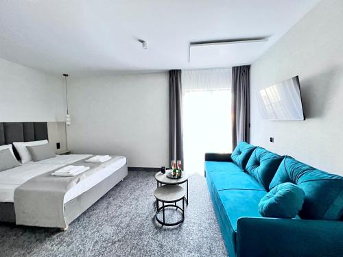 a living room with a blue couch and a bed at SILVER BALTIC in Kołobrzeg