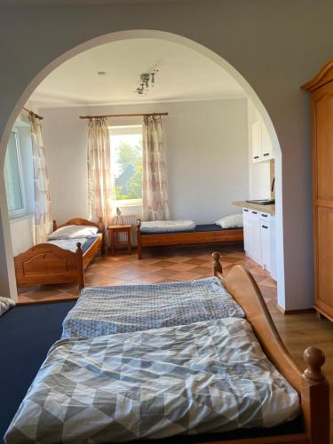 a bedroom with a large bed and a kitchen at Willa Słoneczny Brzeg pokoje in Jastrzębia Góra