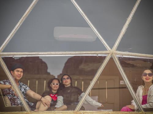 a group of people are sitting in a mirror at RUM NEPTUNE lUXURY CAMP in Wadi Rum