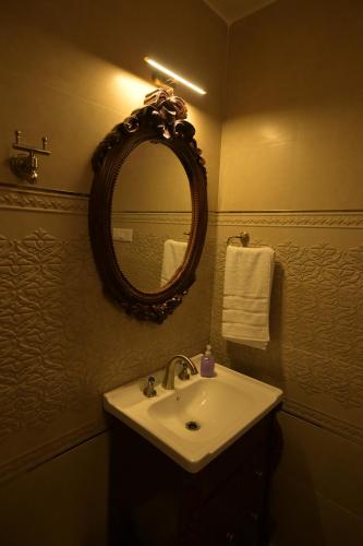 a bathroom with a sink and a mirror and towels at Rajkamal-The Himalayan Heritage in Shimla