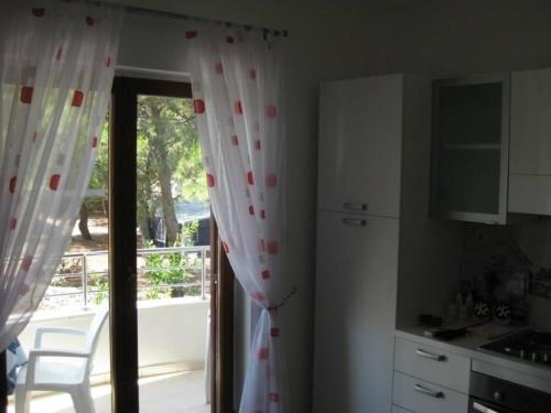 uma cozinha com uma porta de vidro deslizante para uma varanda em Ferienwohnung für 4 Personen ca 45 qm in Srima, Dalmatien Norddalmatien - b60464 em Srima