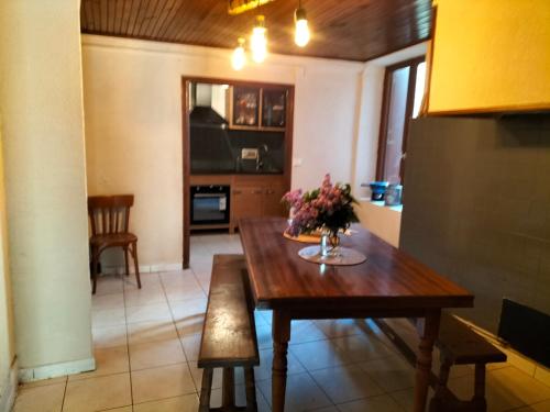 une cuisine avec une table en bois et des fleurs. dans l'établissement La planque, à Puilaurens