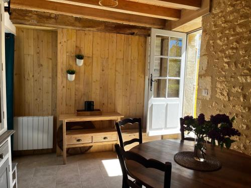 d'une salle à manger avec une table et un mur en bois. dans l'établissement Gite avec extérieur, à Pont-lʼAbbé-dʼArnoult