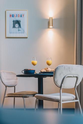two chairs and a table with two glasses of wine at LVM Stays in The Hague