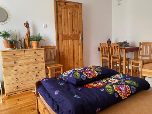 sypialnia z łóżkiem i drewnianą komodą w obiekcie Apartament Hajstra z ogrodem w mieście Grodzisk