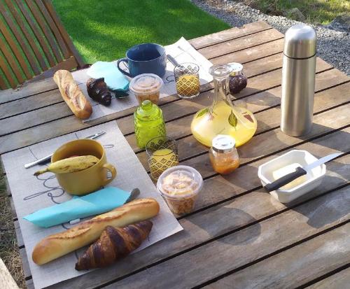 a picnic table with a hot dog and bread on it at Tipi sous les étoiles avec petit déjeuner in Lucéram