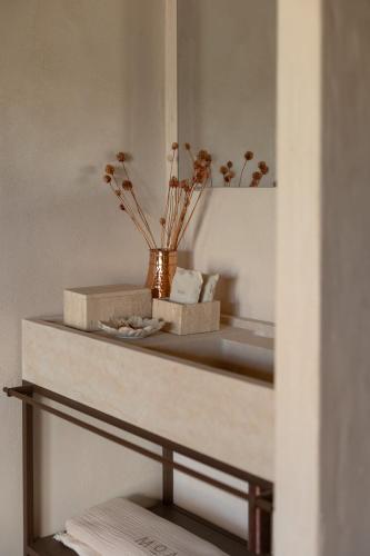 a shelf with a mirror and a vase with flowers at Moa Living in Ẕofar