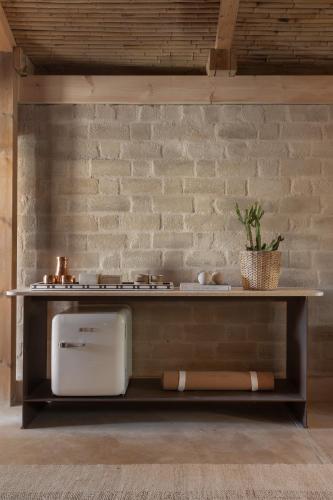 a counter in a room with a table against a brick wall at Moa Living in Ẕofar